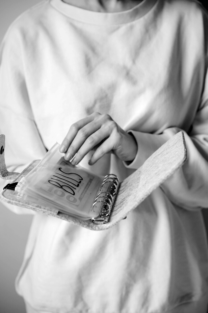 Woman Holding a Book Binder with Bills