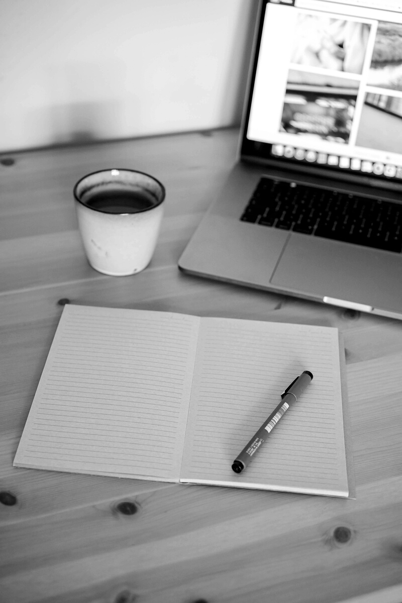 Laptop and Notebook on Wooden Desk